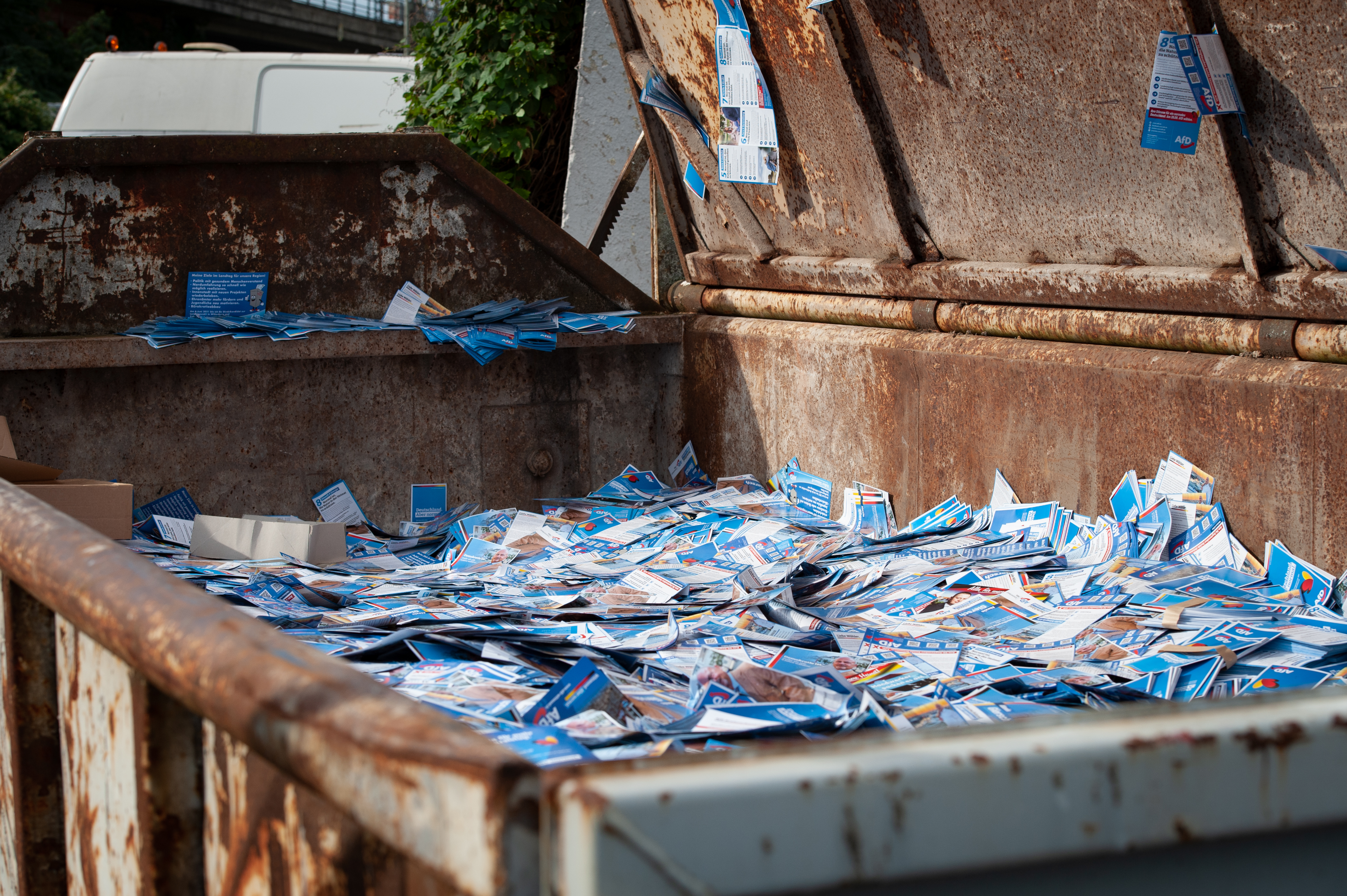 An overview of a waste container with AfD flyers.